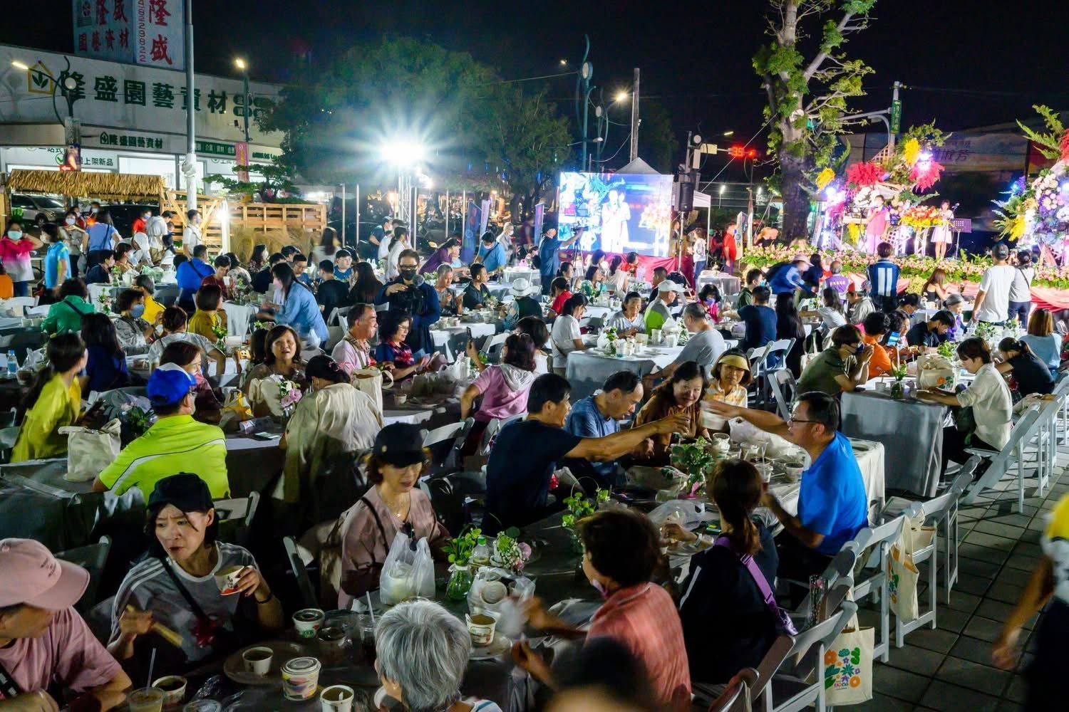 夜裡長桌旁賓客舉杯用餐