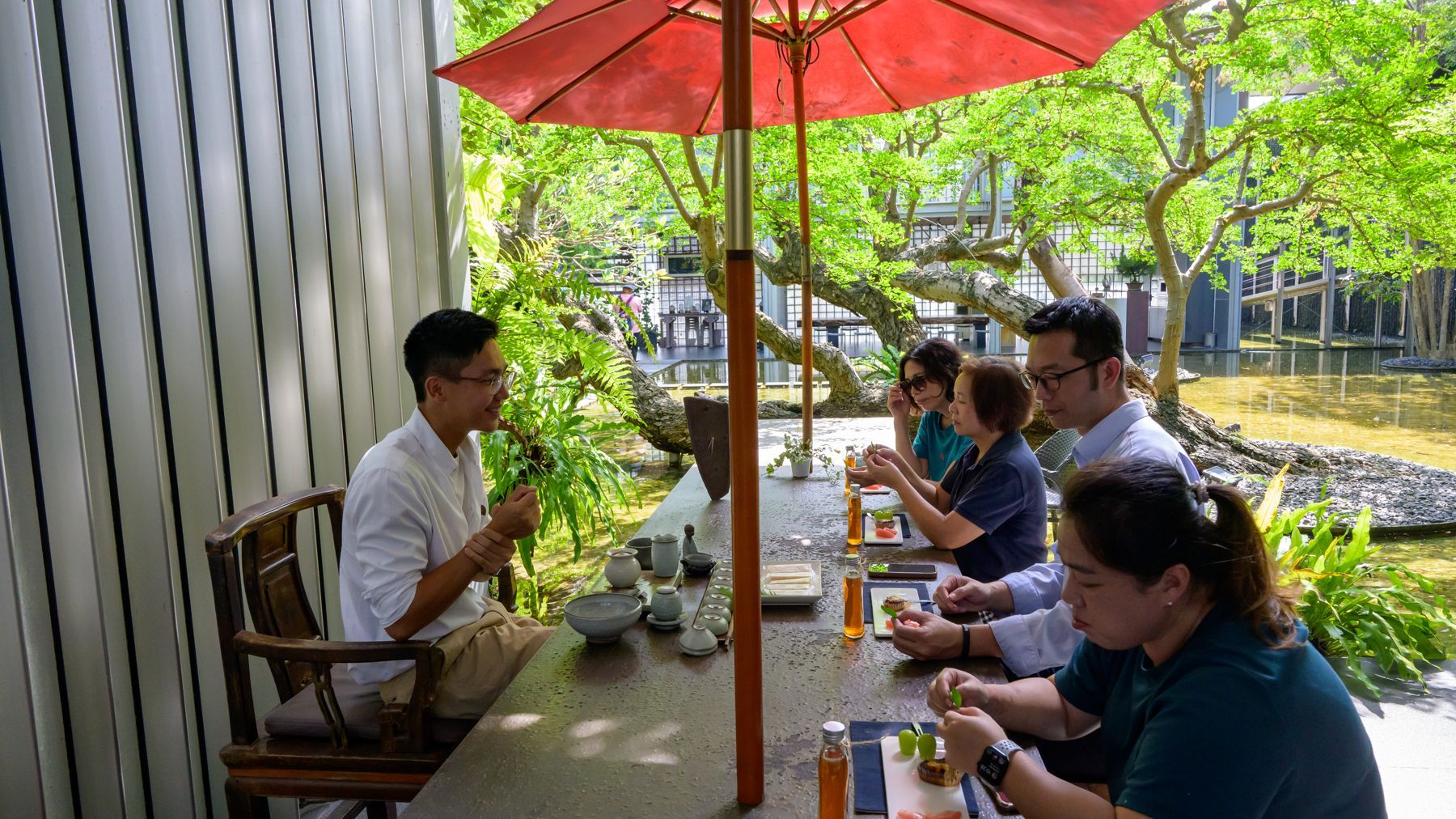 紅傘下的花園茶席,幾位客人圍桌品茶